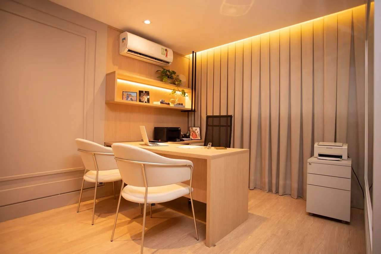 Sala de consulta com mesa de atendimento e cadeiras